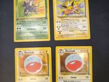 four pokemon cards sitting on top of a table next to each other