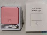 packaging of a pink portable printer sitting on top of a white box