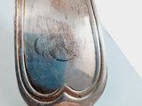 a silver spoon sitting on top of a white table