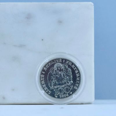 une pièce d'argent posée sur un bloc de marbre blanc