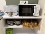 a microwave that is sitting on a shelf in the kitchen
