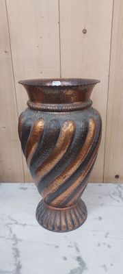 un vase marron et noir posé sur une table