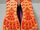 the soles of a pair of running shoes with orange soles
