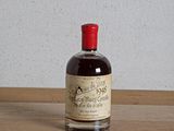 une bouteille d'alcool posée sur une table à côté d'une bouteille de vin