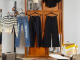 une pièce avec des vêtements suspendus à un portant et une chaise placée devant celui-ci