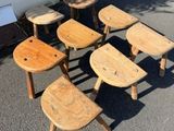 six tabourets en bois posés au milieu d'un parking