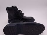 the sole of a pair of black leather boots on a white surface