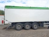 a white truck with a green top parked in a parking lot