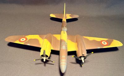 une maquette d'avion jaune et noir posée sur une surface grise