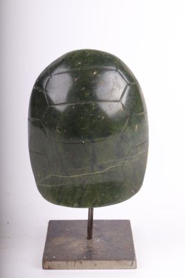 sculpture représentant une sphère en pierre verte posée sur un socle en bois