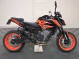 an image of a black and orange motorcycle parked in a garage