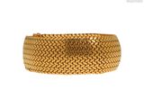 gros plan d'un bracelet en or sur fond blanc