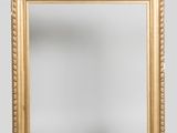an image of a gold framed mirror against a white wall
