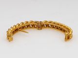 a close up of a gold bracelet on a white surface
