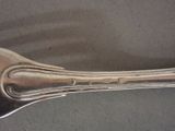a silver spoon with a long handle on a table