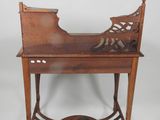 an antique wooden desk with a carved top and a drawer