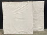 two white sheets of plastic sitting on top of a cement floor