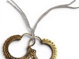 pair of gold hoop earrings on a white background with a ribbon