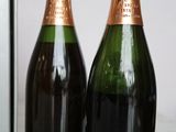 two bottles of champagne sitting next to each other on a table