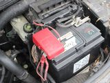 a red battery in the engine bay of a car