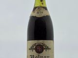 une vieille bouteille de vin rouge posée sur une table