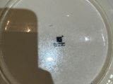 a white plate with a black cat on it sitting on a table