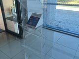 a clear display case with a book on it in front of a glass door