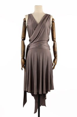 le mannequin porte une robe avec un pan qui l'enveloppe