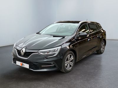 Une voiture noire est garée dans une pièce aux murs blancs.