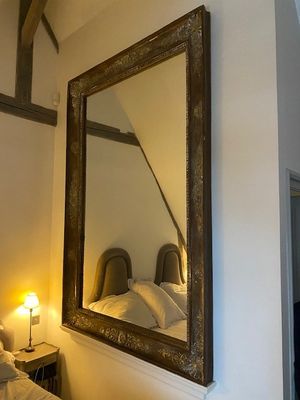 a large mirror hanging on the wall above a bed