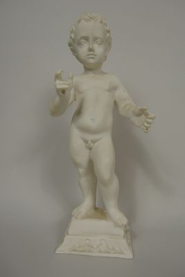 a white statue of a boy holding something in his hand