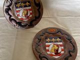 deux assiettes décoratives posées sur une table, sur fond blanc