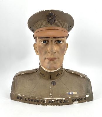 une statue représentant un homme en uniforme sur fond blanc