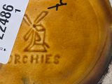 a close up of a yellow vase with a sticker on it