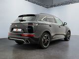 the rear end of a grey car parked in a garage