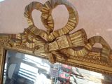 a mirror with a gold frame and a pair of rings on it