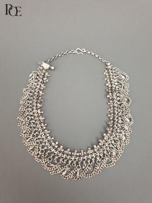 un collier en argent sur fond gris
