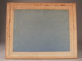 an old picture frame sitting on top of a table next to a wall