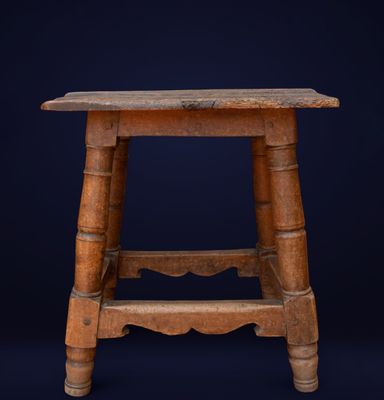 an old wooden stool against a dark blue background