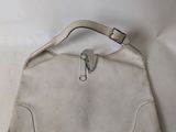 beige leather purse with a zippered handle on a white background