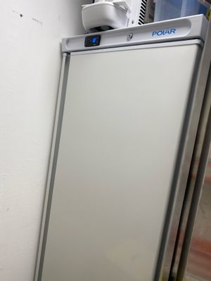 un réfrigérateur blanc dans le coin d'une pièce