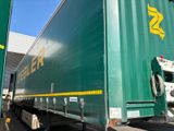 a large green truck parked in front of a building