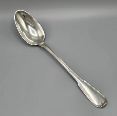 une cuillère en argent à long manche posée sur une table