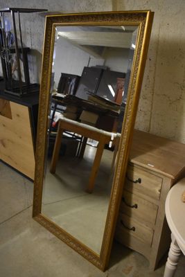 un miroir posé par terre à côté d'une table