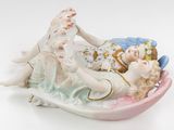 a figurine of a woman and a child laying on a boat