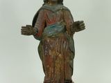 une vieille statue représentant une femme coiffée d'une couronne