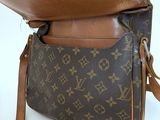 a close up of a brown louis vuitton bag on a white surface