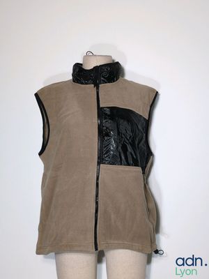 une photo d'un mannequin portant un gilet beige orné de bordures en cuir noir