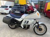 a silver motorcycle parked in a parking lot next to some cars