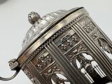 a silver metal object with a bird in a cage on it